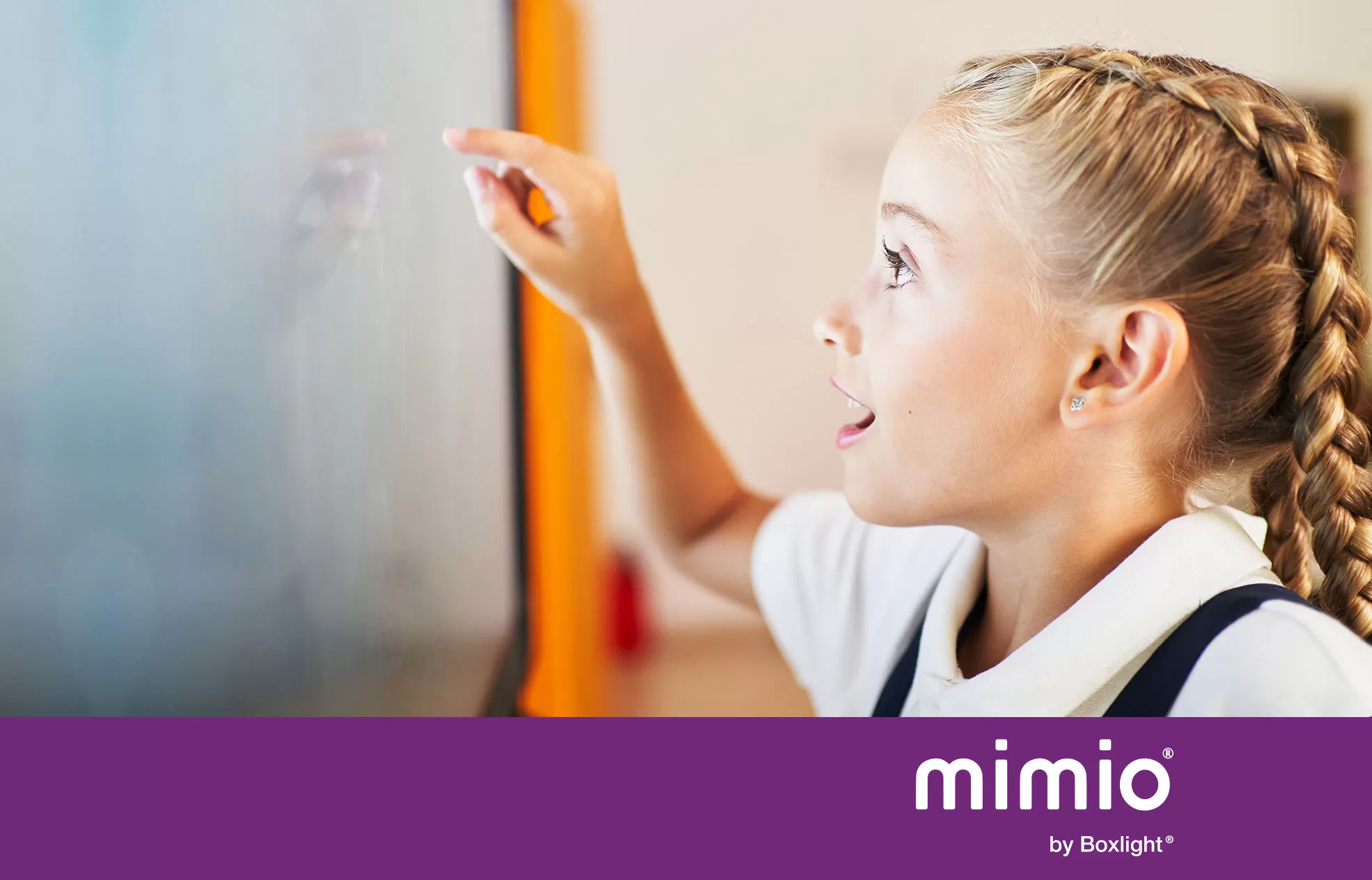 Student using the MimioPro4 touchscreen with a purple banner across the bottom saying 'mimio by Boxlight'