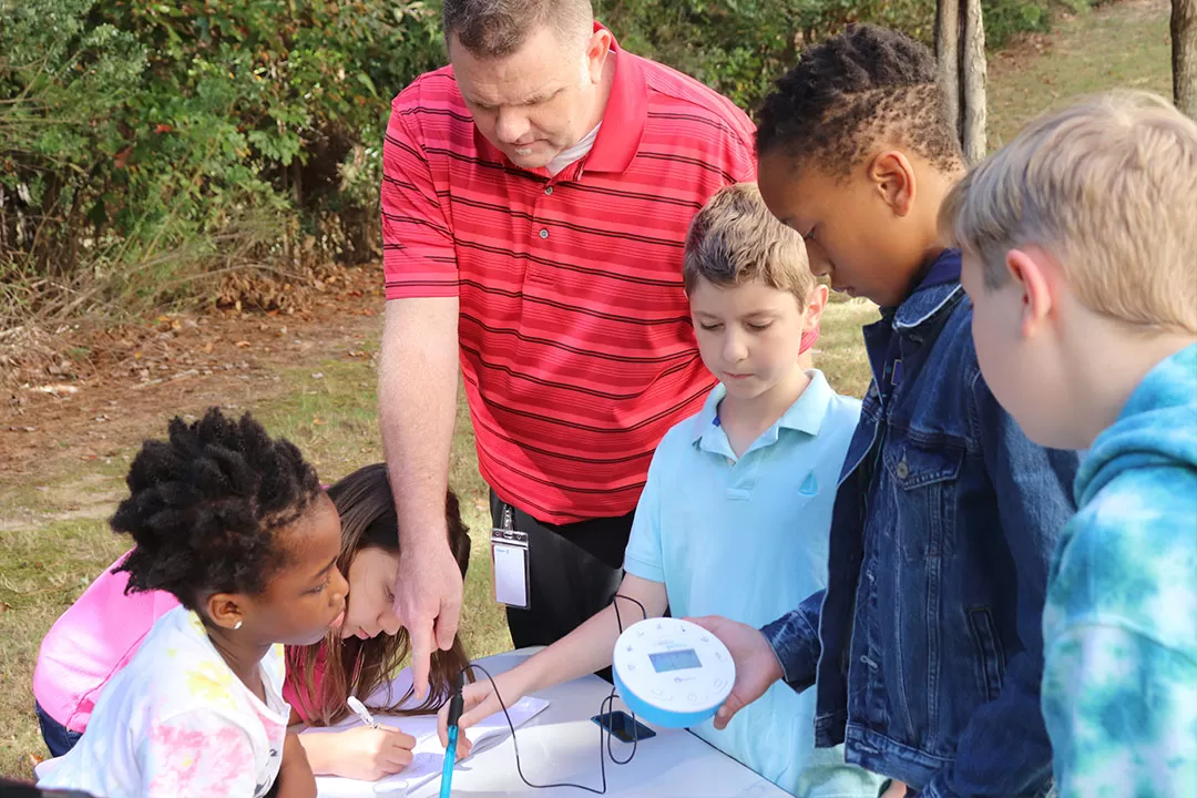 teacher and students using the lab disk outside