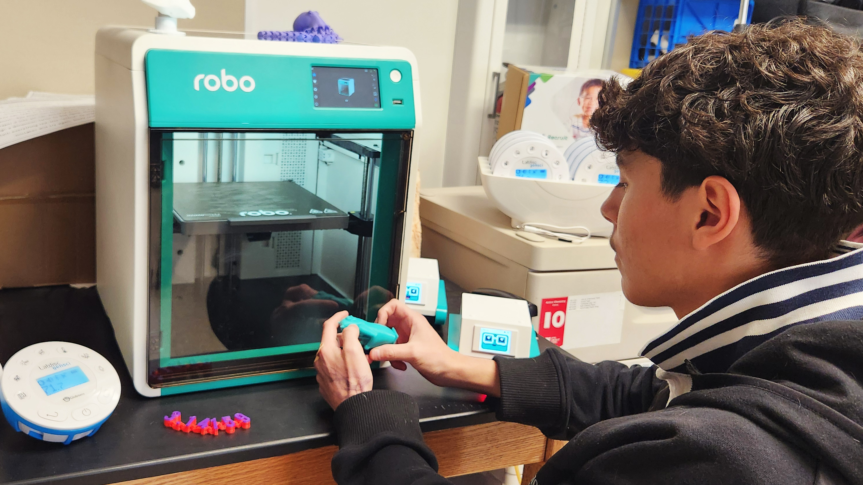 Student holding a 3D printed T-Rex scull